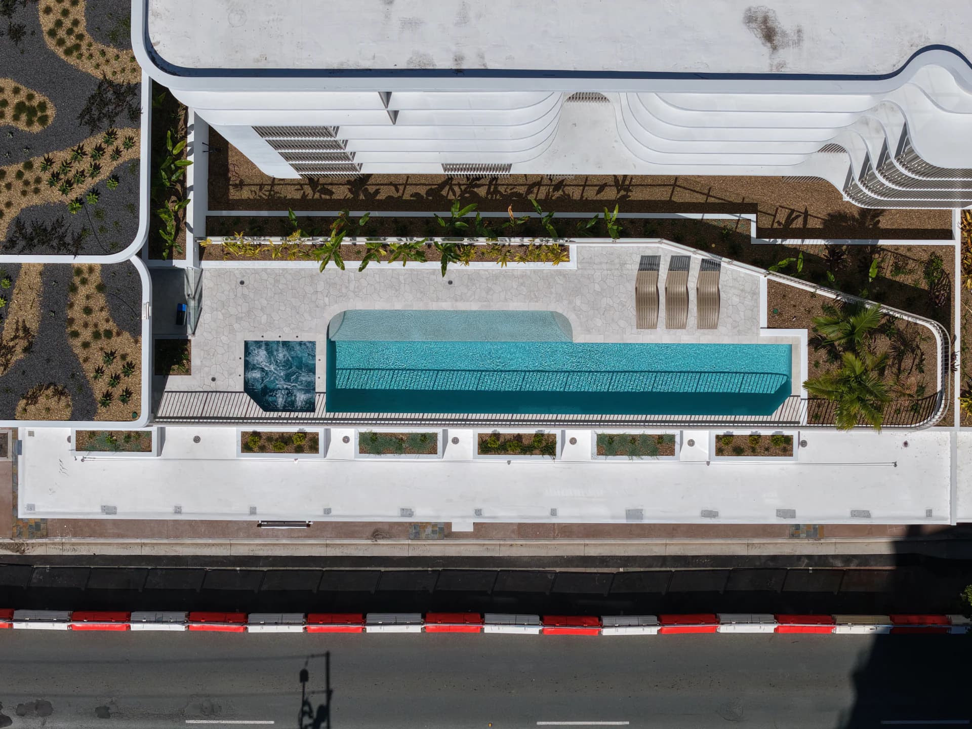 Overhead view of a completed pool, surrounding building and landscaped outdoor areas.